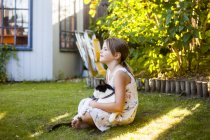 Дівчина грає з кішкою на задньому дворі — стокове фото