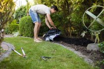 Uomo che diffonde fertilizzante in giardino — Foto stock