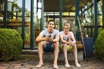 Отец и сын сидят снаружи дома — стоковое фото