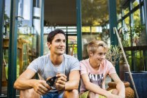 Father and son sitting outside house — Stock Photo