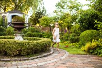 Glückliches Mädchen läuft im Garten — Stockfoto