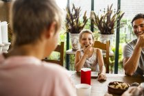 Menina tendo biscoito no café da manhã familiar — Fotografia de Stock