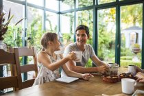 Happy girl having breakfast with father — Stock Photo