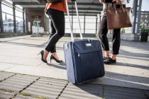 Businesswomen with luggage standing — Stock Photo