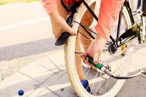 Mujer deportiva inflando bicicleta - foto de stock