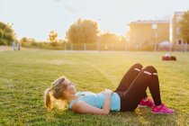 Fit woman lying on grass — Stock Photo
