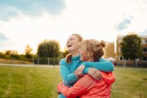 Счастливые женщины обнимаются на поле — стоковое фото