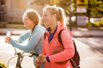 Amigos femininos em pé de bicicleta — Fotografia de Stock