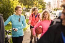 Friends walking with bicycles — Stock Photo