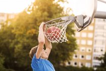 Garçon faisant slam dunk — Photo de stock