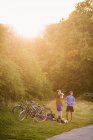 Men standing by bicycles at park — Stock Photo