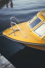 Barco amarillo amarrado en el lago - foto de stock