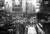 Persone con ombrelloni sotto la pioggia — Foto stock