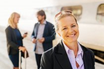 Femme d'affaires heureuse debout à la gare — Photo de stock