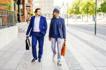 Businessmen walking on sidewalk — Stock Photo