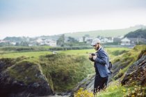 Мужчина фотографирует на холме — стоковое фото