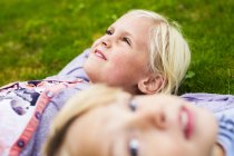 Girl with brother lying on grass — Stock Photo