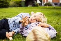 Boy lying on his sisters stomach — Stock Photo