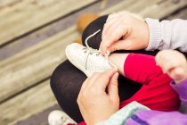 Madre mettere scarpe su figlia — Foto stock