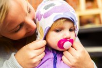Madre regolazione cappuccio sulla testa babys — Foto stock