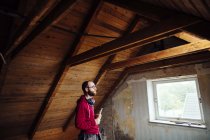 Uomo che ispeziona soffitta — Foto stock