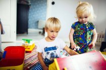 Fratello e sorella giocare con i giocattoli — Foto stock