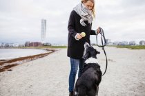 Frau mit Hund am Strand — Stockfoto