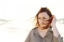 Mujer con cabello barrido por el viento al aire libre - foto de stock