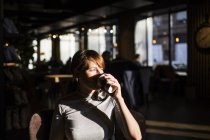 Donna che beve caffè al caffè — Foto stock