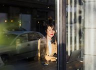 Woman looking through window — Stock Photo