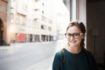 Media mujer de negocios adulta sonriendo por oficina - foto de stock