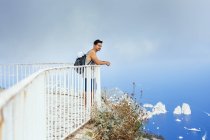 Junger Mann steht am Geländer — Stockfoto