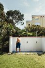 Side view of man bathing under shower in yard — Stock Photo