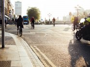 Persone che vanno in bicicletta sulla strada della città — Foto stock