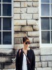 Donna alla moda in piedi contro il muro — Foto stock