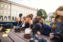 Friends sitting at table in park — Stock Photo