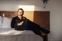Бізнесмен сидить на ліжку в готельному номері — стокове фото