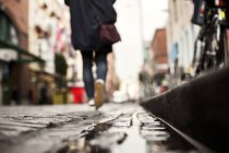 Person walking on wet footpath — Stock Photo