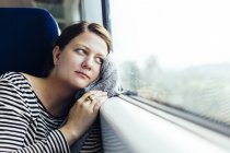 Business woman looking out through train window — стоковое фото