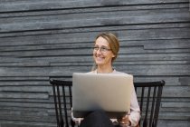 Heureuse femme d'affaires avec ordinateur portable — Photo de stock