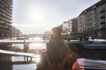 Woman standing by canal in city — Stock Photo