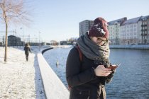 Woman using smartphone by canal — Stock Photo