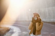Woman photographing with camera outdoors — Stock Photo