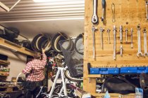 Чоловік працює в велосипедному магазині — стокове фото
