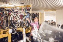 Mechanic working in bicycle shop — Stock Photo