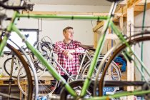 Mechaniker stützt sich auf Fahrrad — Stockfoto