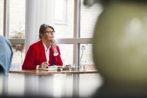 Gedachte Geschäftsfrau sitzt am Tisch — Stockfoto
