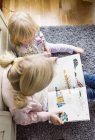 Sisters reading book — Stock Photo