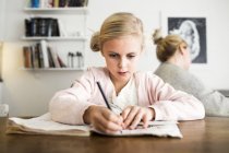 Mädchen macht Hausaufgaben am Schreibtisch — Stockfoto