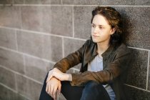 Teenage boy leaning against wall — Stock Photo